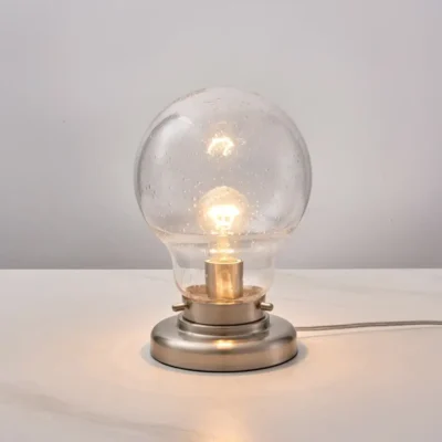 Brighten your space with Bubble Glass Table Lamp, a masterpiece of lighting that combines elegance and functionality. Made of aluminium and with a luxurious brushed nickel finish. This table lamp is the perfect addition to any room. Pair this lamp with the rest of the Bubble Glass collection for a complete look!