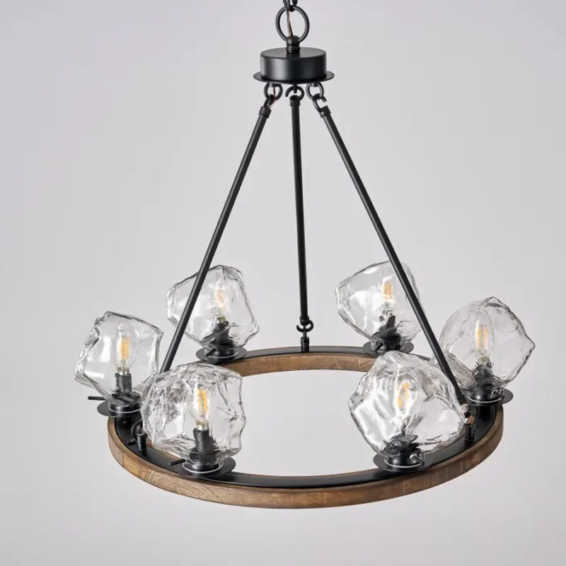 Farmhouse style meets modern minimalist on this Crystal Wood Flyer Chandelier. This vintage-style linear chandelier is compatible with sloped ceilings. 6 irregularly shaped glass lampshade perches on the wooden round base, each designed to house an E12 candelabra base bulb (not included) that adds a candle style to this linear chandelier. Let the warm glow of this embrace you with this farmhouse kitchen island chandelier rustic matte black and wood-like finish.