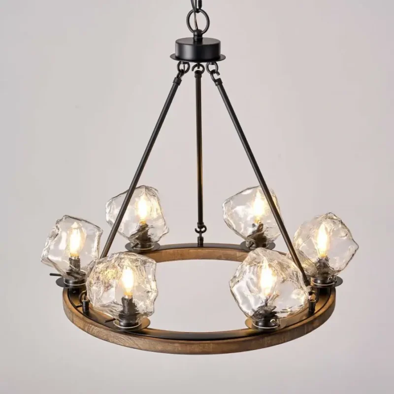 Farmhouse style meets modern minimalist on this Crystal Wood Flyer Chandelier. This vintage-style linear chandelier is compatible with sloped ceilings. 6 irregularly shaped glass lampshade perches on the wooden round base, each designed to house an E12 candelabra base bulb (not included) that adds a candle style to this linear chandelier. Let the warm glow of this embrace you with this farmhouse kitchen island chandelier rustic matte black and wood-like finish.