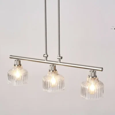 A minimalist masterpiece that seamlessly blends captivating design with functional brilliance, this chandelier transcends the ordinary. Featuring hand-blown glass pendant that commands attention from above, this chandelier will effortlessly accent a space of any size. Suspended elegantly from a sleek metal, the chandelier allows light to playfully dance within its clear glass confines, creating a mesmerizing interplay of shadows and illumination. Combining high-quality metal construction and adjustable height functionality, this pendant light fixture offers a unique lighting experience.