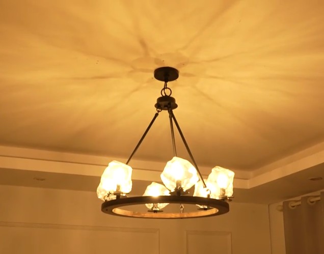 Farmhouse style meets modern minimalist on this Crystal Wood Flyer Chandelier. This vintage-style linear chandelier is compatible with sloped ceilings. 6 irregularly shaped glass lampshade perches on the wooden round base, each designed to house an E12 candelabra base bulb (not included) that adds a candle style to this linear chandelier. Let the warm glow of this embrace you with this farmhouse kitchen island chandelier rustic matte black and wood-like finish.