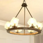 Farmhouse style meets modern minimalist on this Crystal Wood Flyer Chandelier. This vintage-style linear chandelier is compatible with sloped ceilings. 6 irregularly shaped glass lampshade perches on the wooden round base, each designed to house an E12 candelabra base bulb (not included) that adds a candle style to this linear chandelier. Let the warm glow of this embrace you with this farmhouse kitchen island chandelier rustic matte black and wood-like finish.